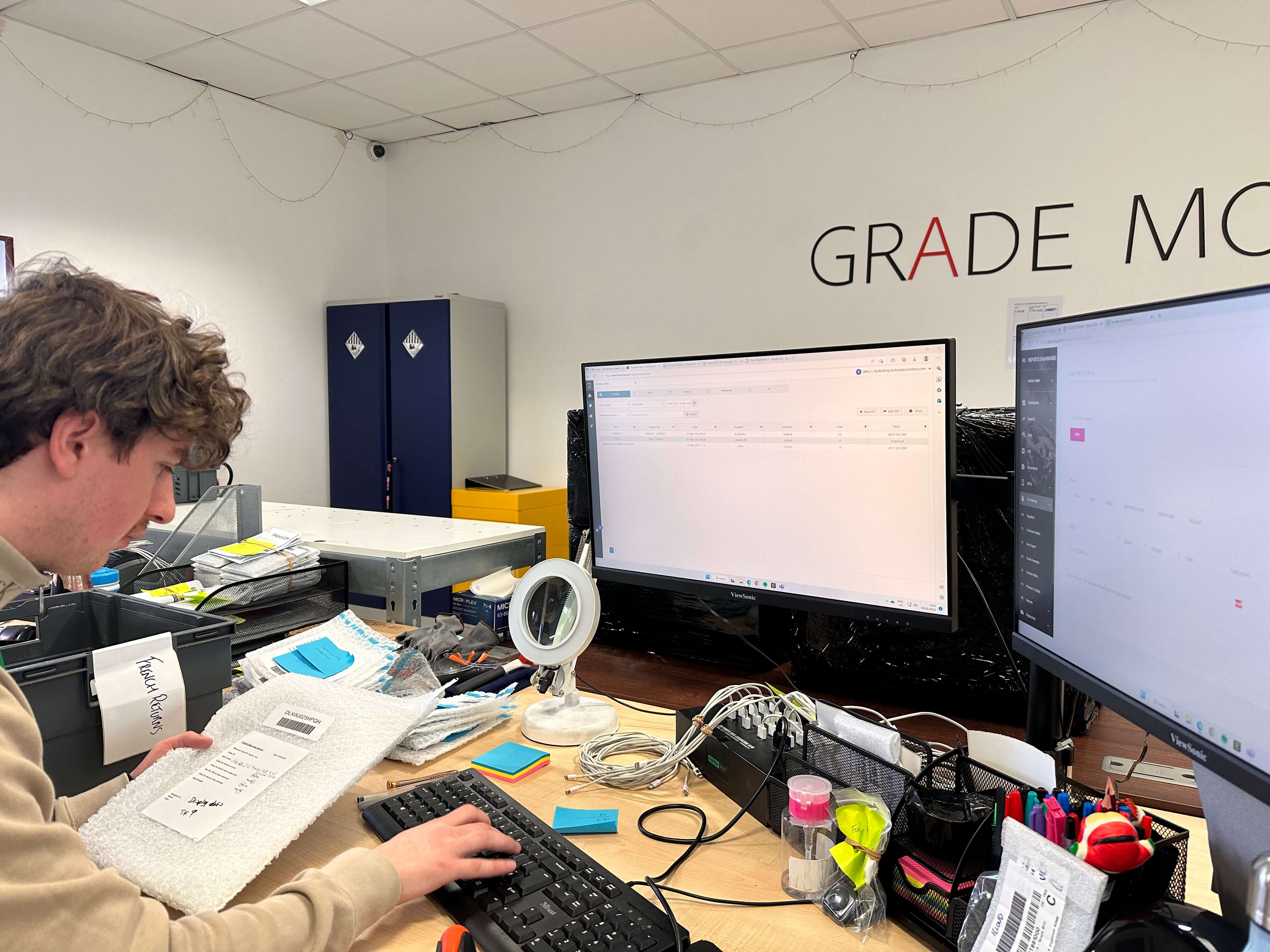 man at desk of computer checking in items